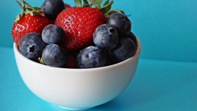 blueberries and strawberries in white ceramic bowl